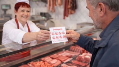 Kundenbindung im Lebensmittelhandwerk: Eine Fleischerin übergibt einem Stammkunden an der Theke einen abgestempelten Treuepass. Sammelpässe zählen weiterhin zu den bewährten Instrumenten, um Frequenz, Warenkorb und persönliche Bindung zu stärken. © KI-generiertes Bild / ChatGPT